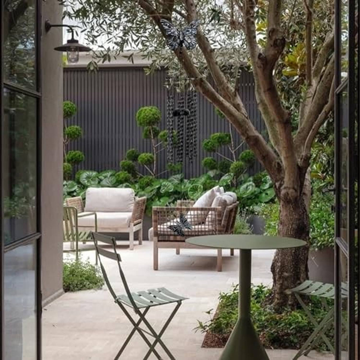 Black and white butterfly wind chime hanging outdoors above garden seating