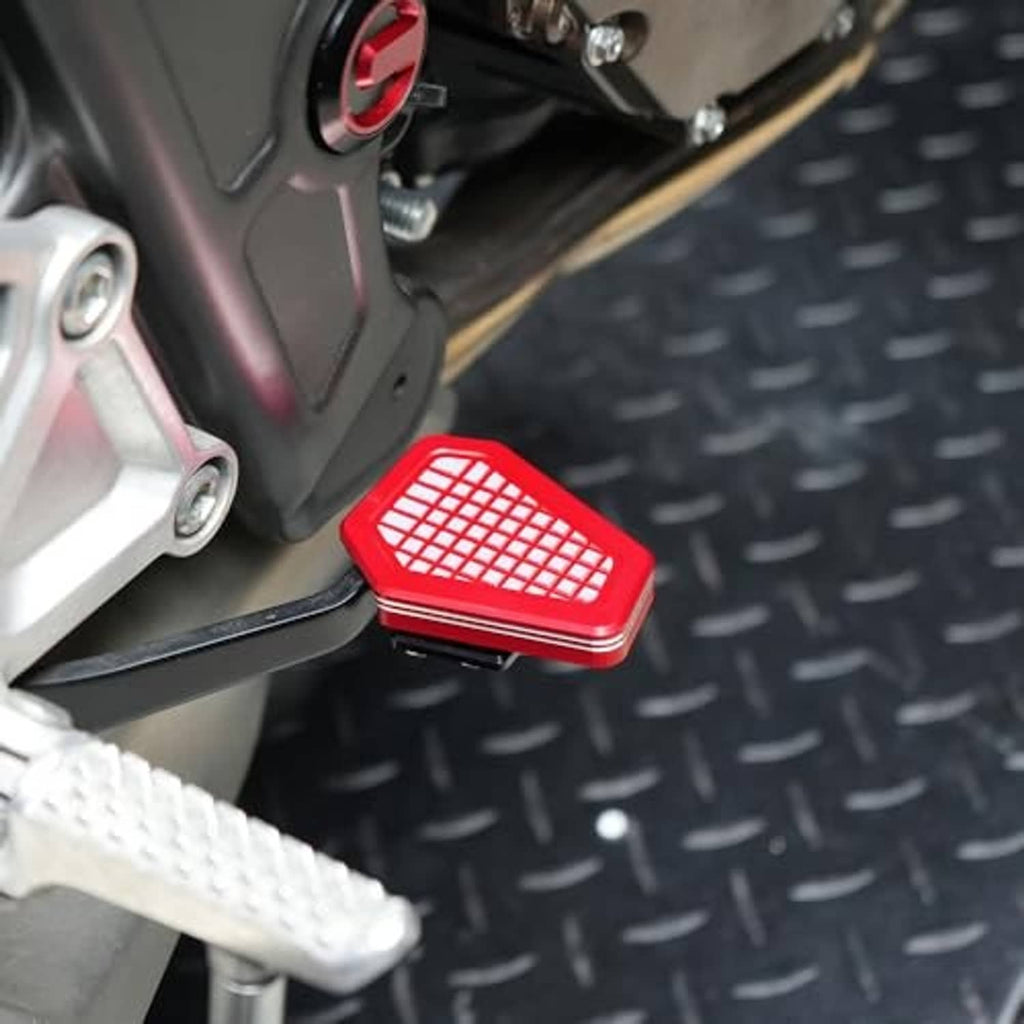 Red anti-slip grid brake lever pedal extender mounted on a motorcycle foot area