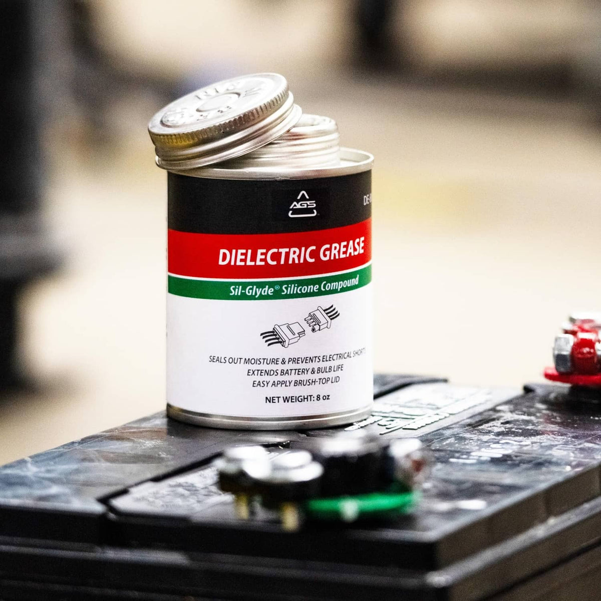 Dielectric silicone grease can standing on an automotive fuse block