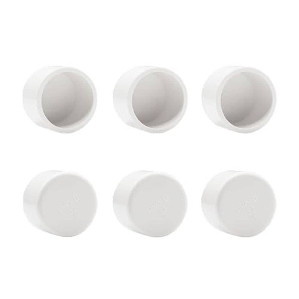Six white PVC pipe end caps with open sockets, shown from an angled view