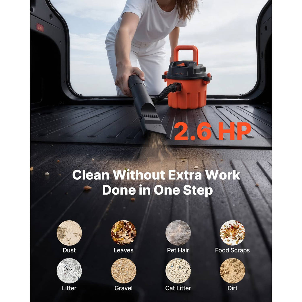 Orange shop vacuum cleaner with floor brush attachment, shown in a vehicle