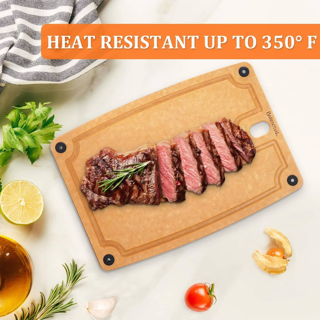 Tan composite cutting board holding sliced steak, with handle hole and corner grip holes