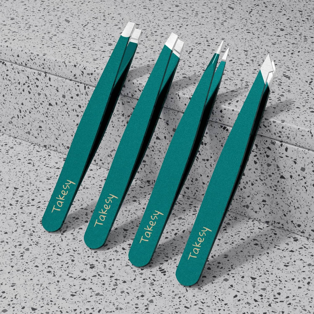 Four forest-green tweezers with pointed metal ends arranged on a speckled surface