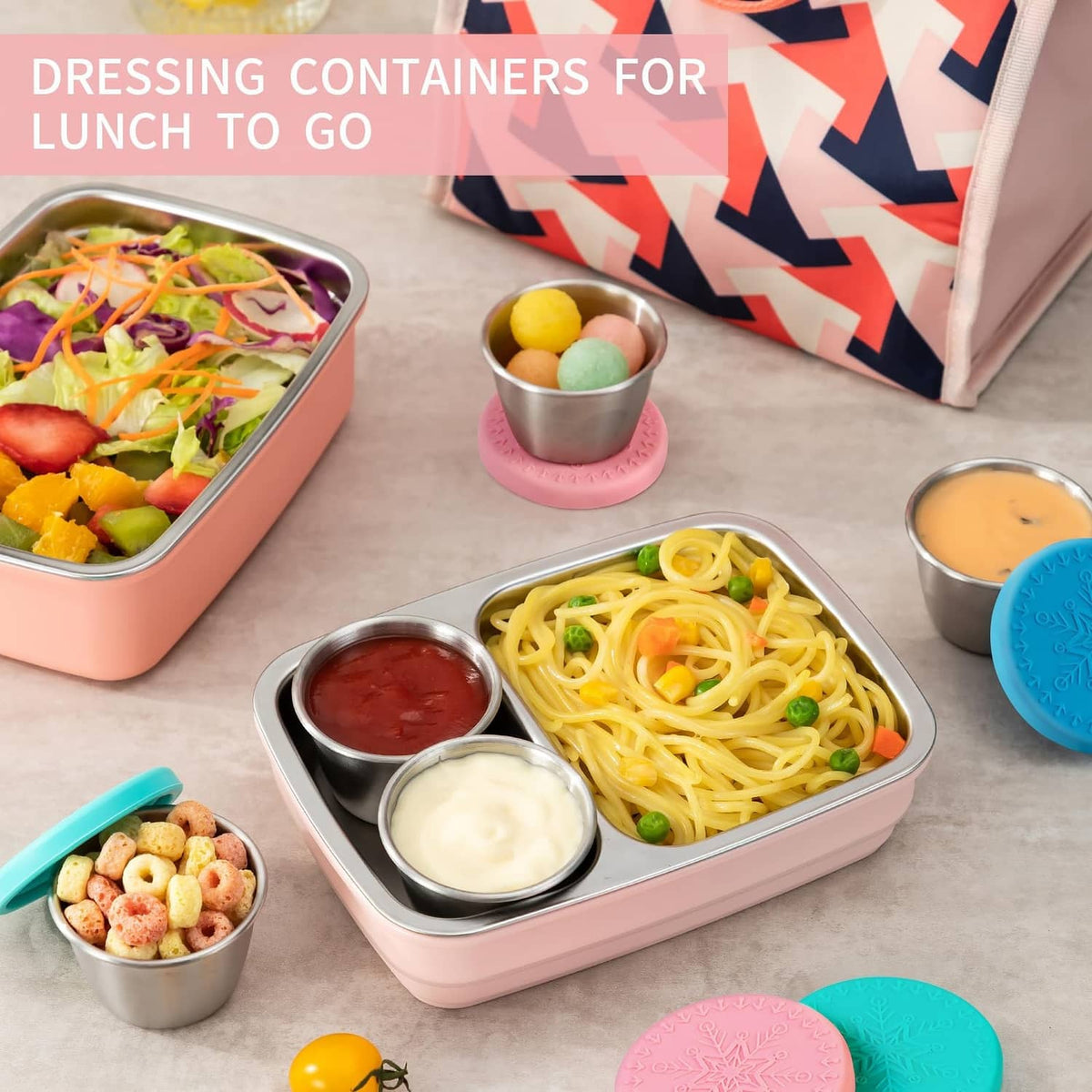 Stainless steel sauce cups with pink and teal silicone lids in lunch storage set