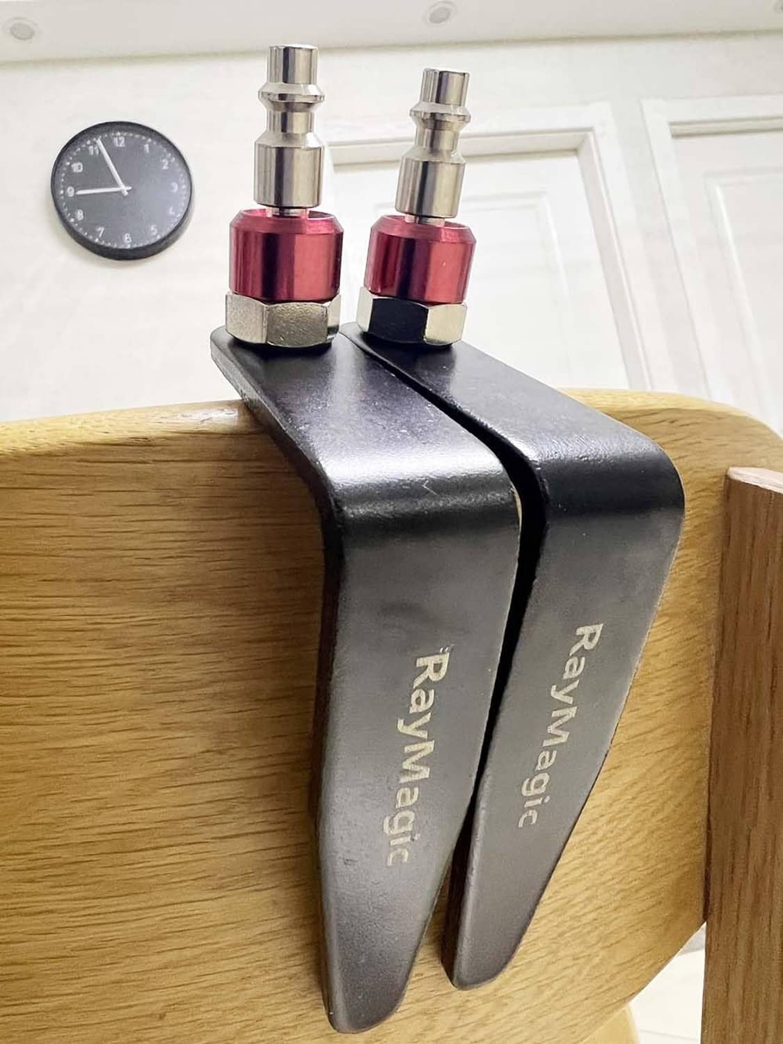 Pair of black rafter hook hangers with red caps mounted on a wooden beam