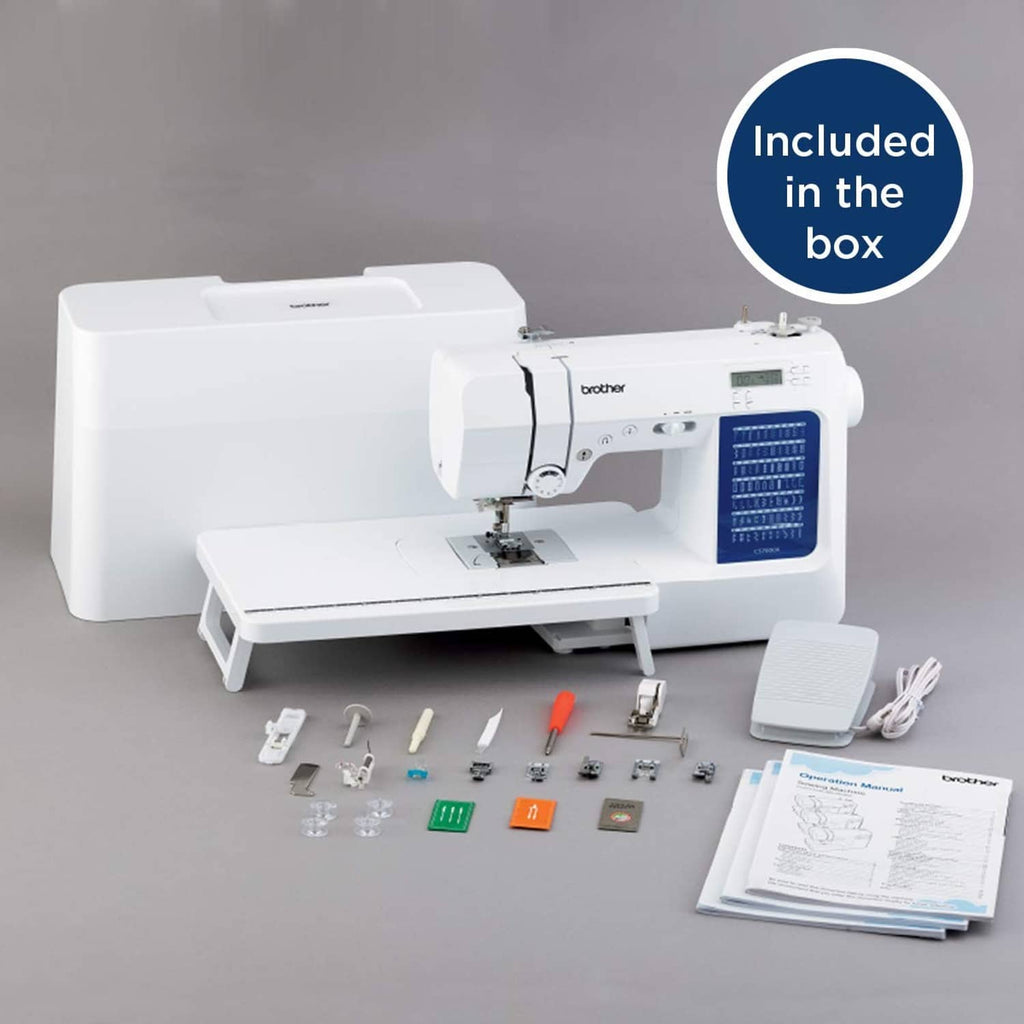 White sewing and quilting machine with included accessories on tabletop