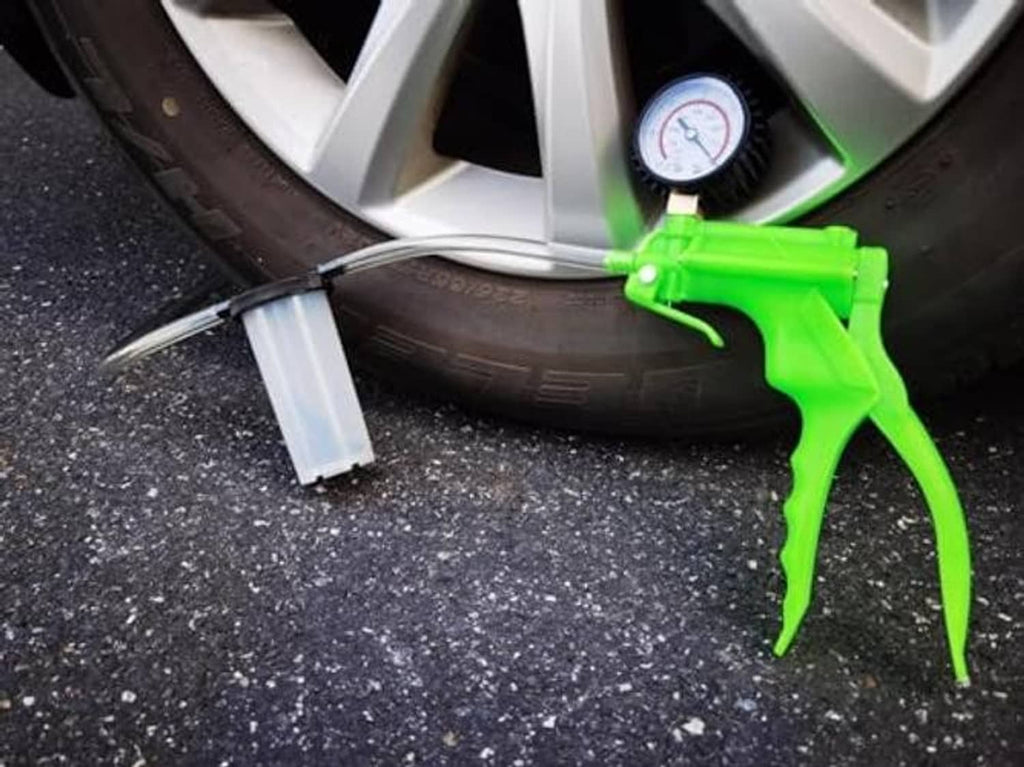 Brake bleeder kit with green hand pump, clear tube, and roadside fluid reservoir cup