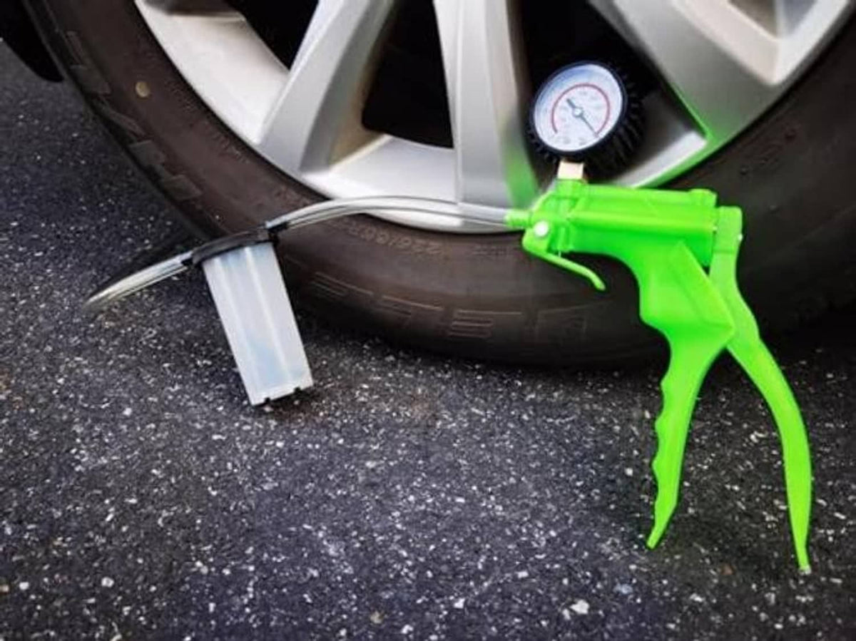 Brake bleeder kit with green hand pump, clear tube, and roadside fluid reservoir cup