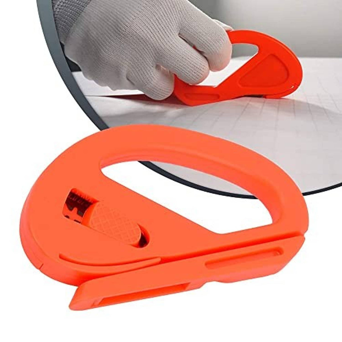 Orange vinyl wrapping tool with felt pad held against film edge for trimming