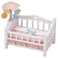 White dollhouse crib with pink bedding and hanging mobile with animal and star charms