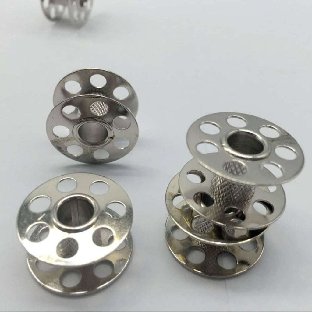 Silver metal bobbins shown from multiple angles, with center hole and mounting slots