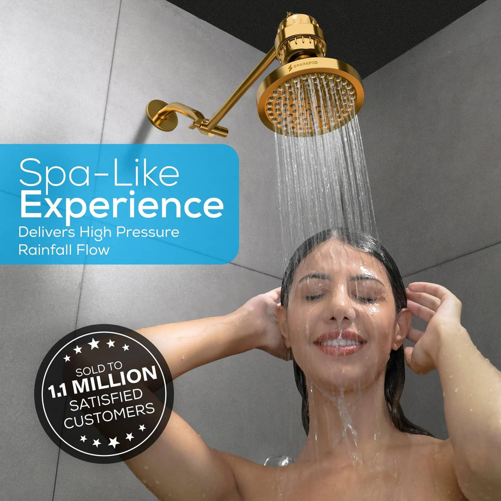 SparkPod 6-inch round rain shower head in Egyptian gold producing a high-pressure rainfall
