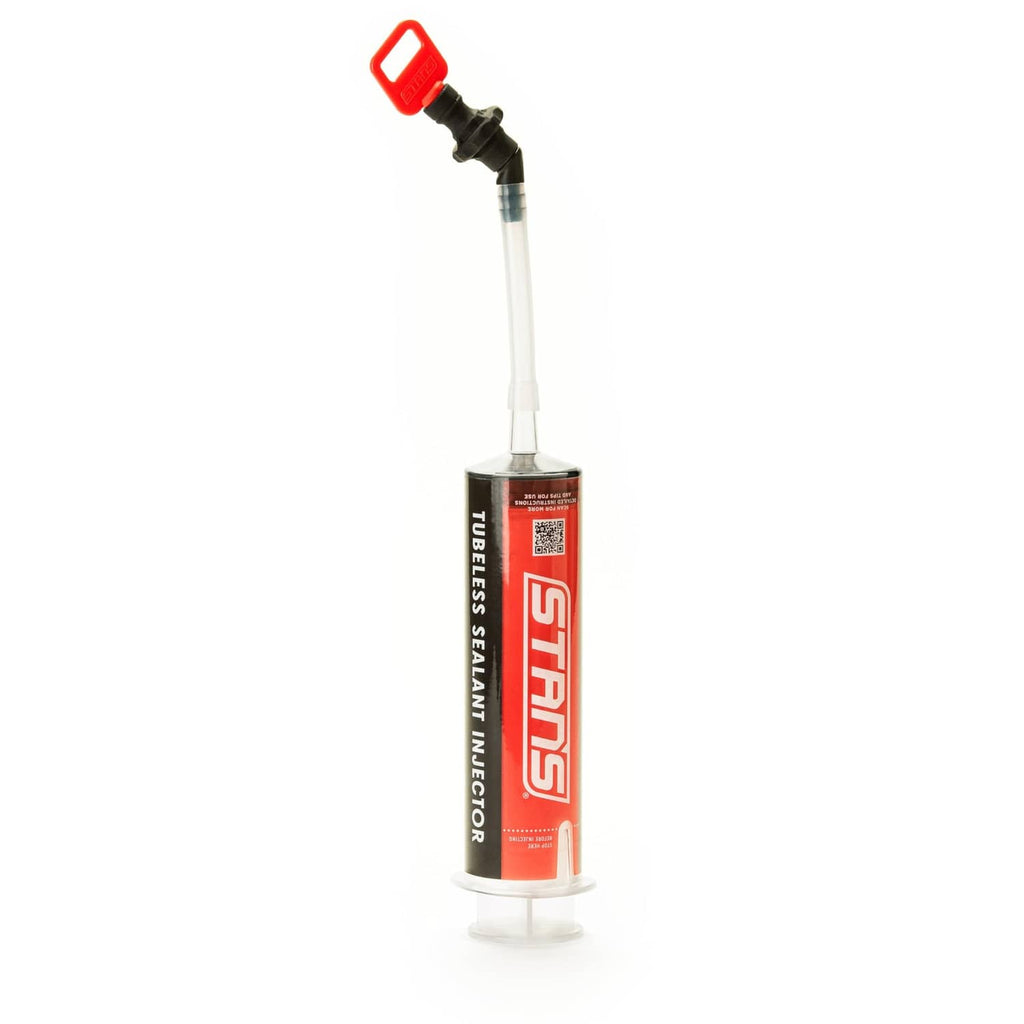 Tubeless sealant injector with red top, black nozzle, and clear dispensing tube