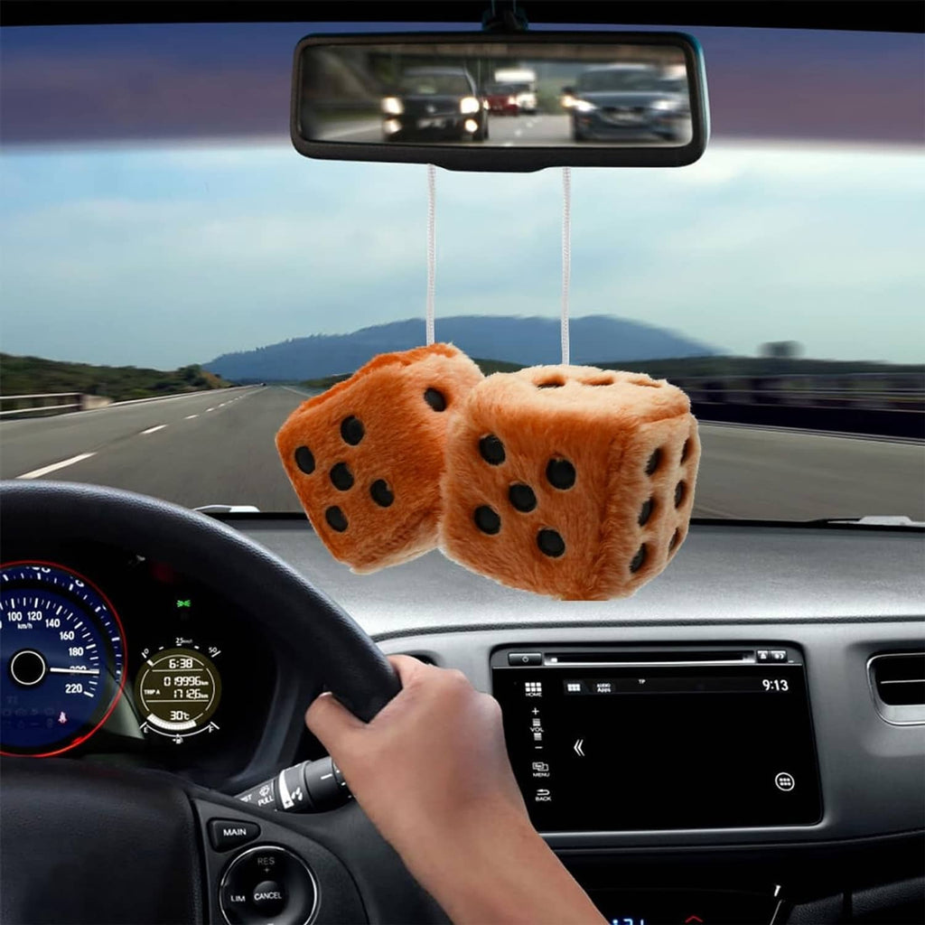 Brown fuzzy plush dice with black dot faces hanging from rearview mirror