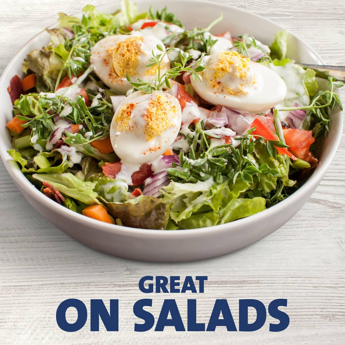 Bowl of mixed salad with sliced vegetables and ranch dressing
