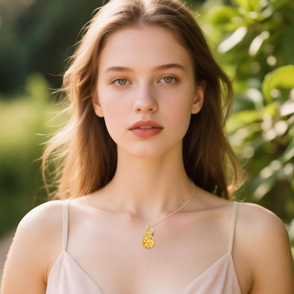 Gold bee pendant necklace on delicate chain, worn on a woman’s neckline