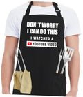 Black kitchen apron with bold quote and YouTube video badge, with utensil pocket detail