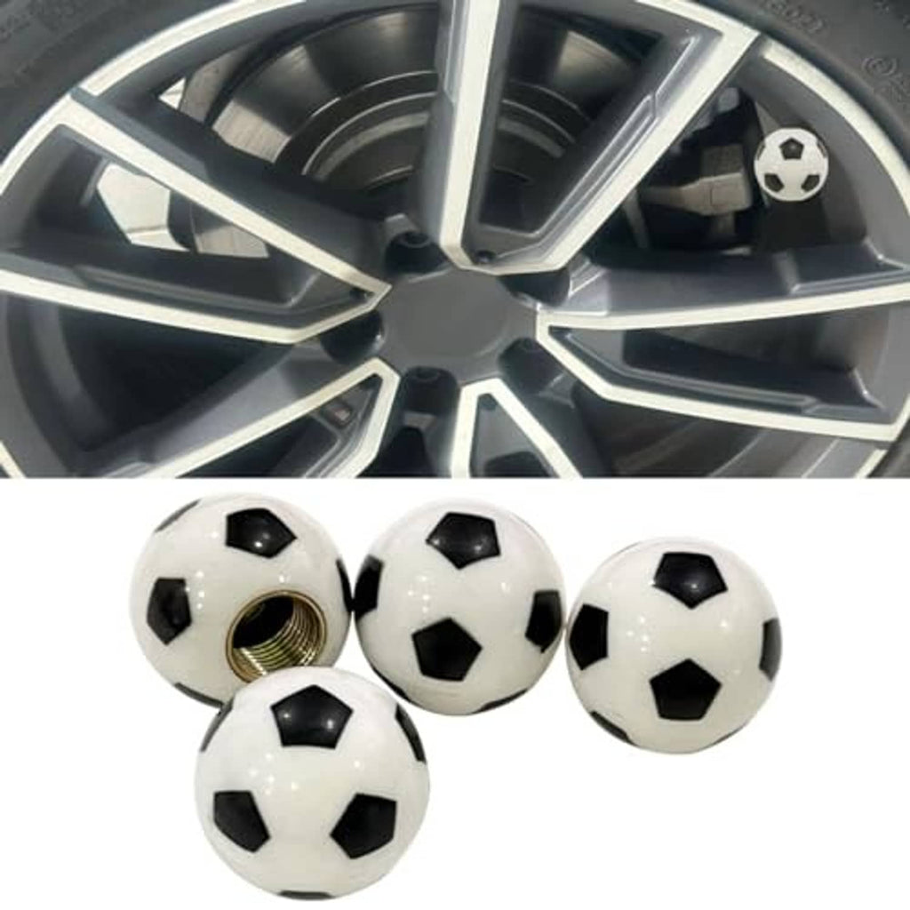 Soccer ball valve stem cap on a car wheel rim, black and white design with brass thread base.
