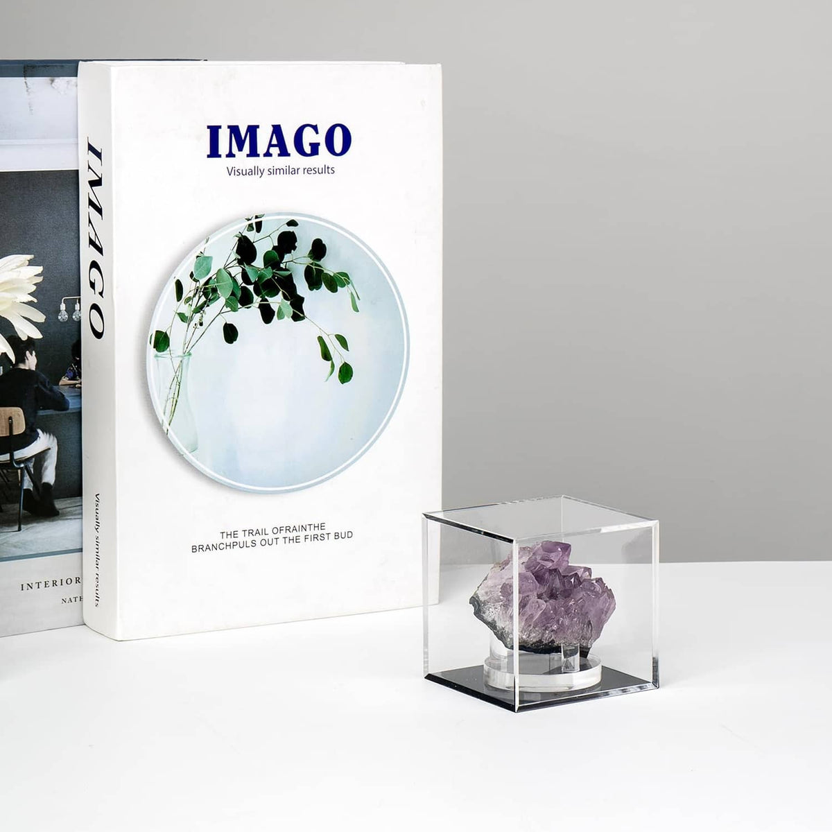 Small clear acrylic display box holding a purple crystal specimen