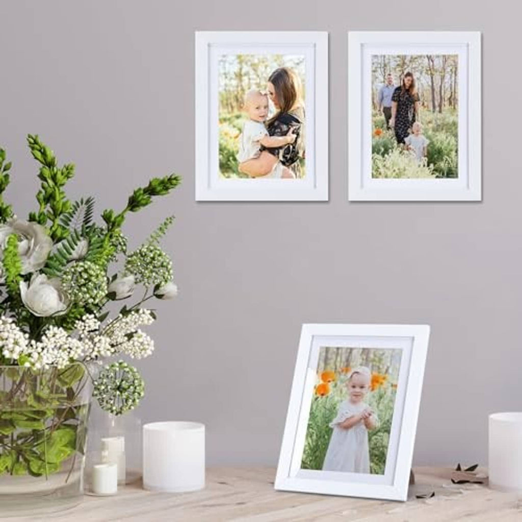 White portrait picture frames, each holding a photo print with a white inner mat
