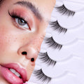 Wispy 3/4 false eyelashes with clear band, layered lash strips presented near model eye