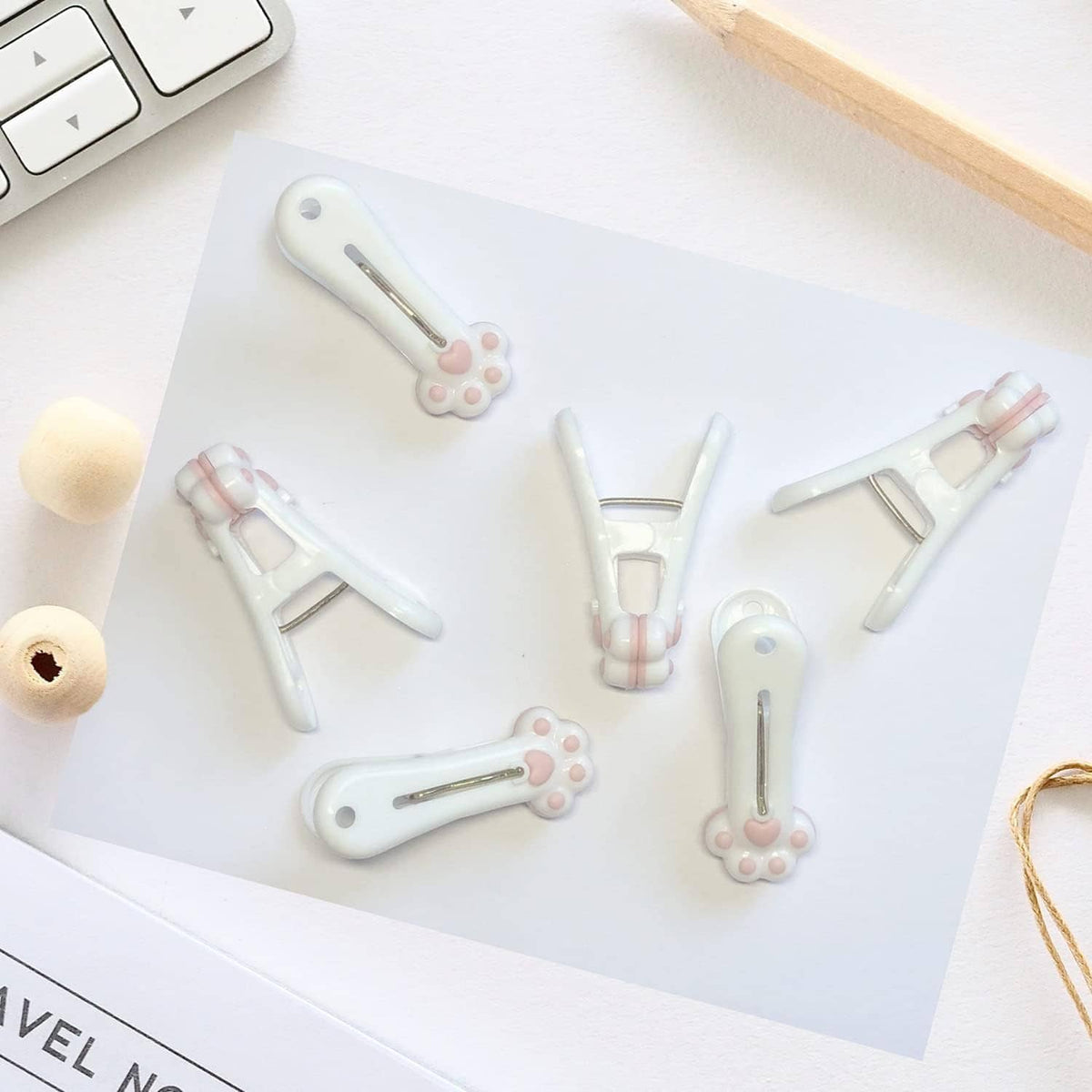 Assorted white plastic clothespins with paw-shaped charms and metal springs