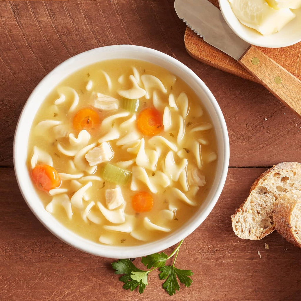 Chicken noodle soup bowl with carrots and chicken pieces in broth