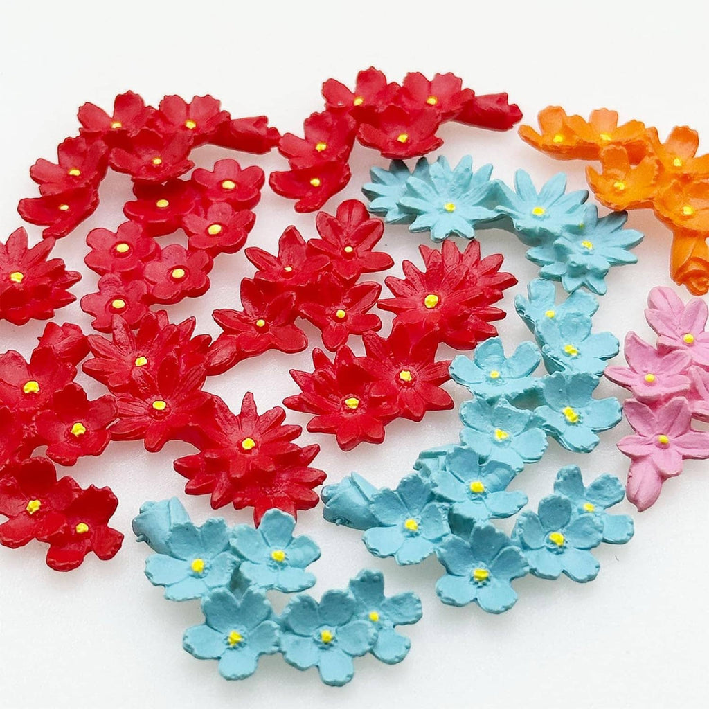 Close-up of mini resin flowers, red and orange plus blue and pink blossoms