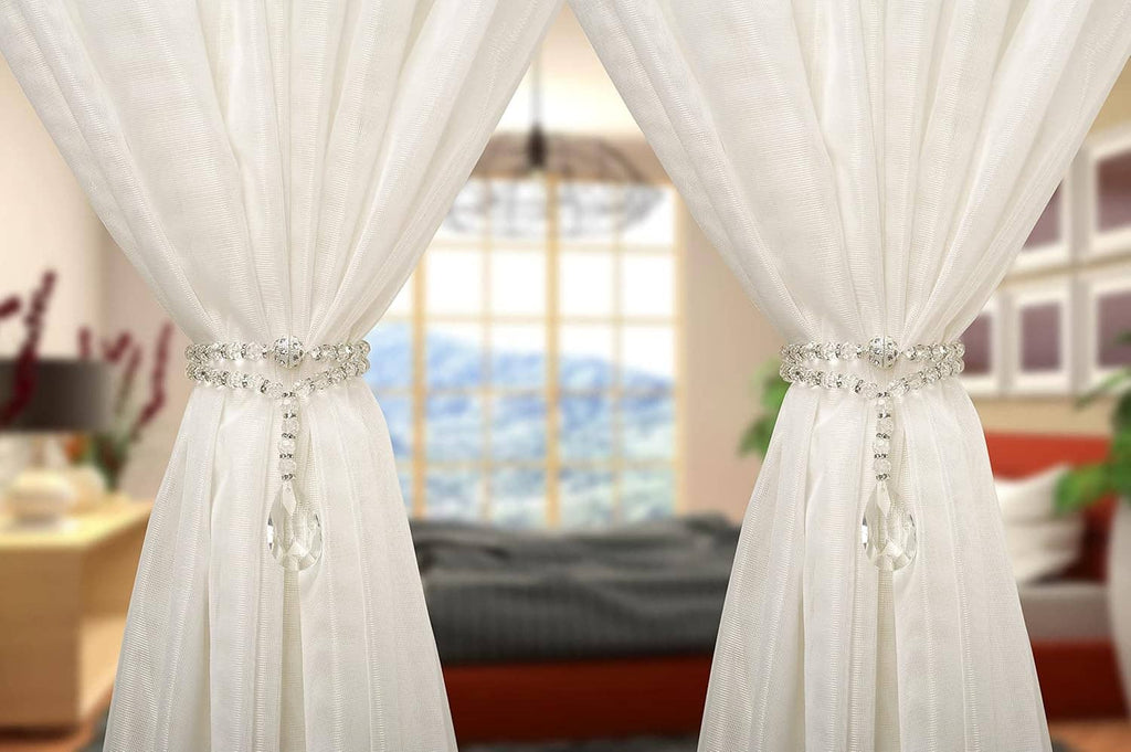 Crystal beaded magnetic curtain holdbacks securing white curtains with teardrop pendants