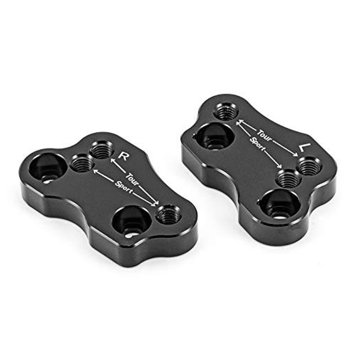 Two black handlebar riser adapters with engraved direction markings and bolt openings