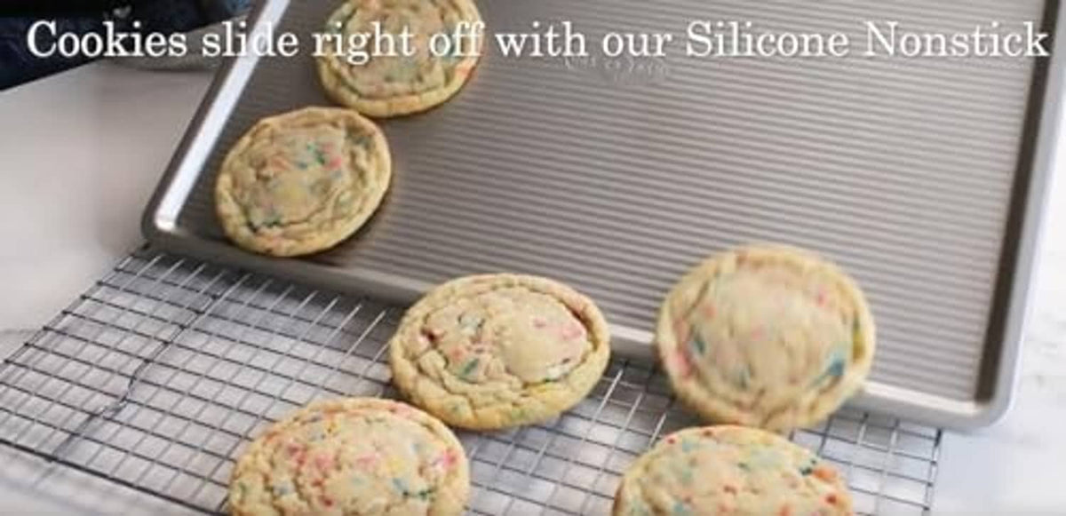 Large cookie sheet with striped surface holding round baked cookies