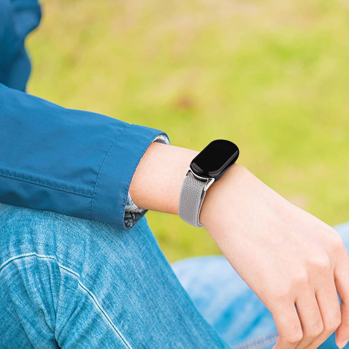 Gray smartwatch band worn on wrist with metal clasp