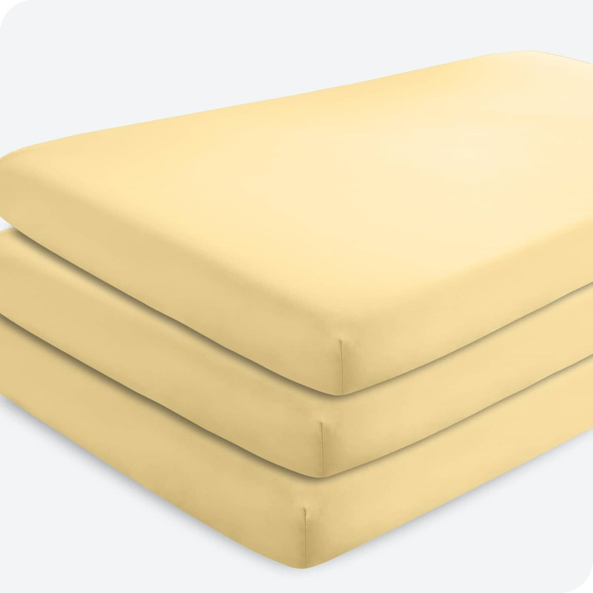 Fitted crib sheet, microfiber in pale yellow, folded with curved corner and elastic edge