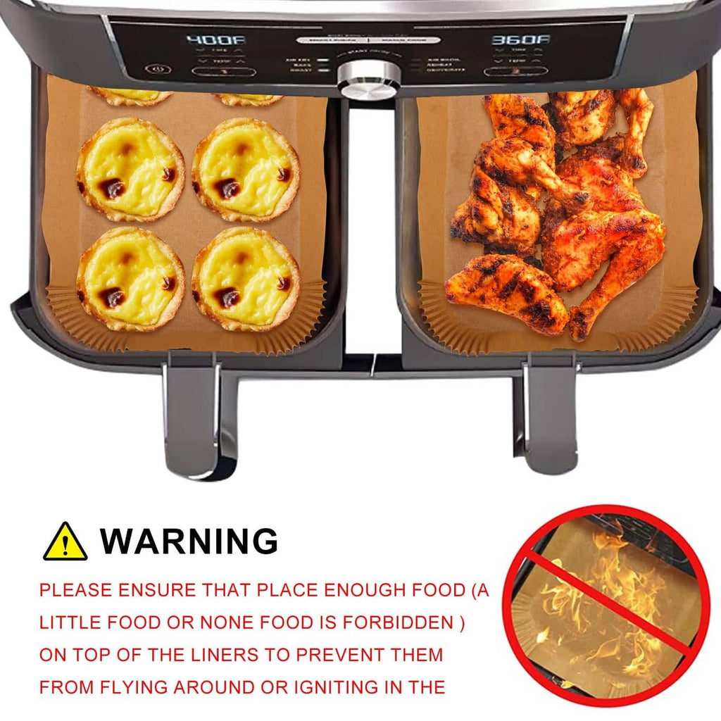 Air fryer baskets lined with brown rectangular paper baking sheets for pastries and chicken