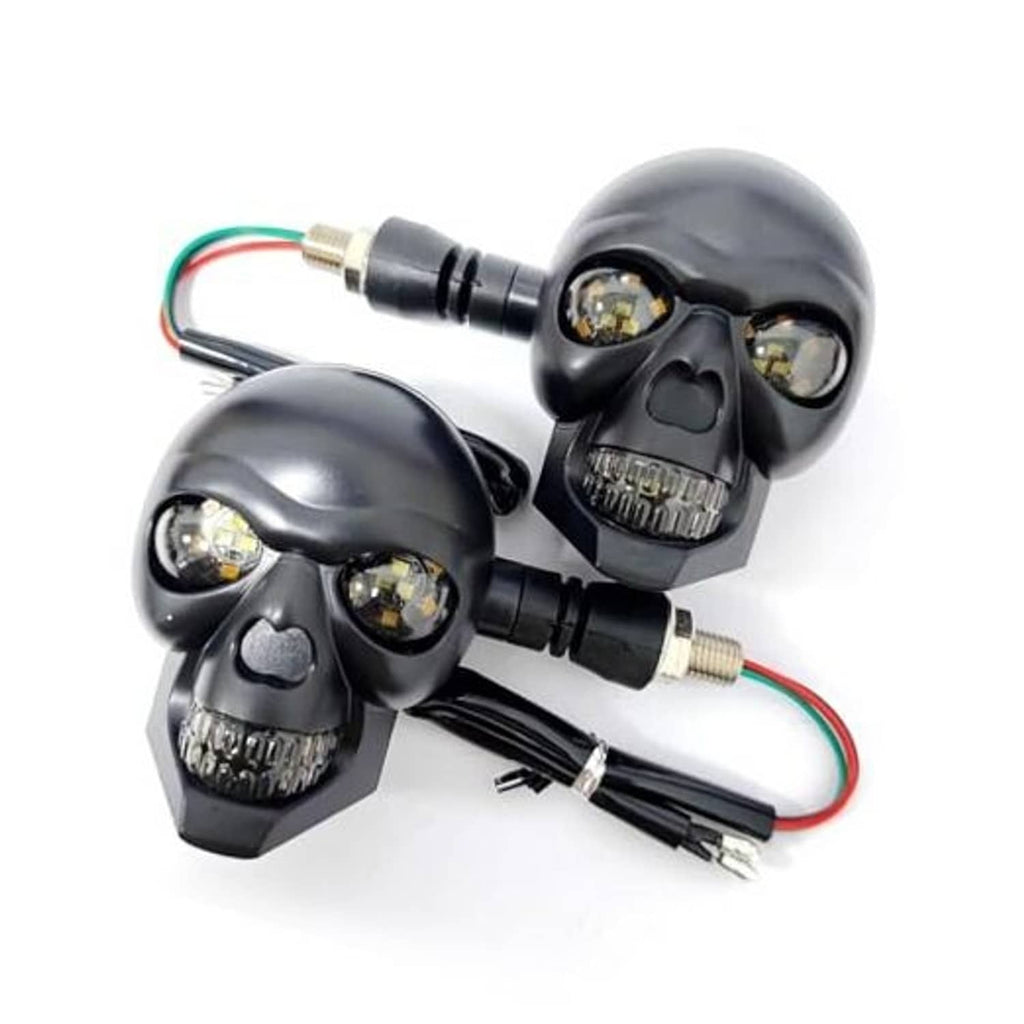 Pair of black skull-shaped LED motorcycle turn signal lights with wiring harness