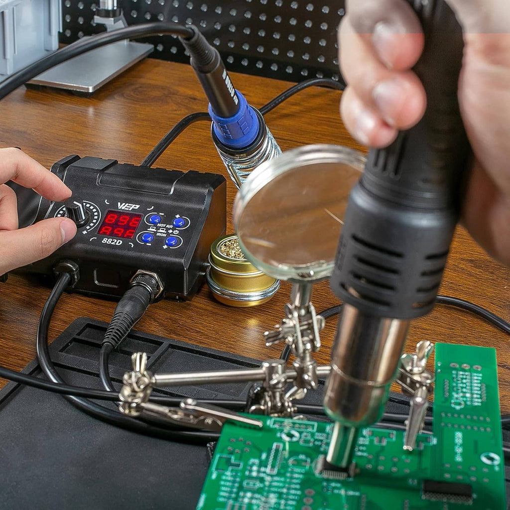 Hot air gun and soldering iron station controls with soldering tools and circuit board