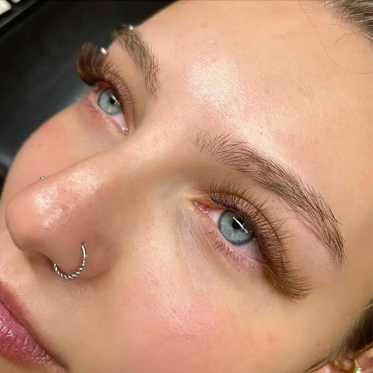 Brown D-curl false lashes on eyelids for a fuller, lifted eye look