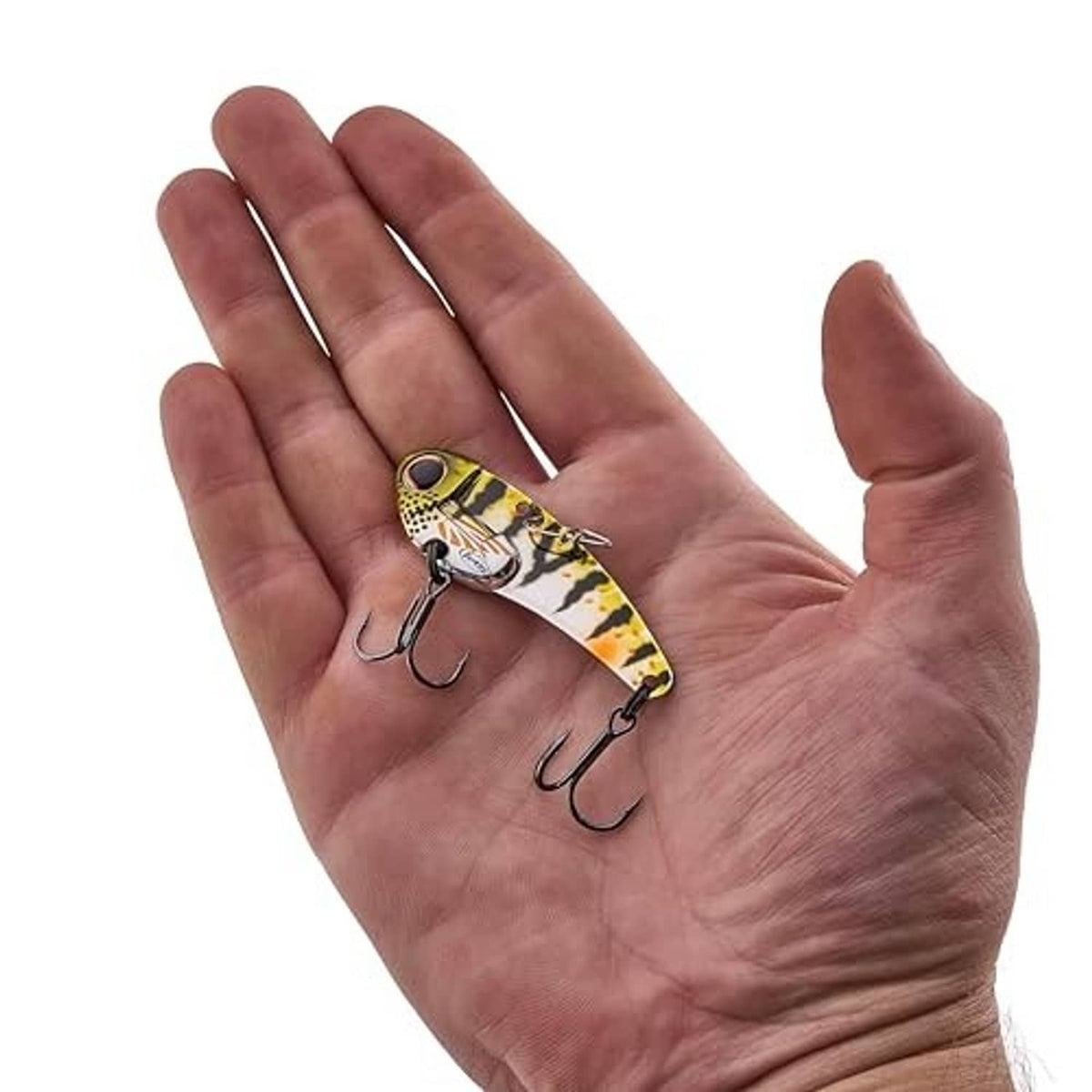 Perch blade bait fishing lure in hand, yellow-green pattern with black treble hooks