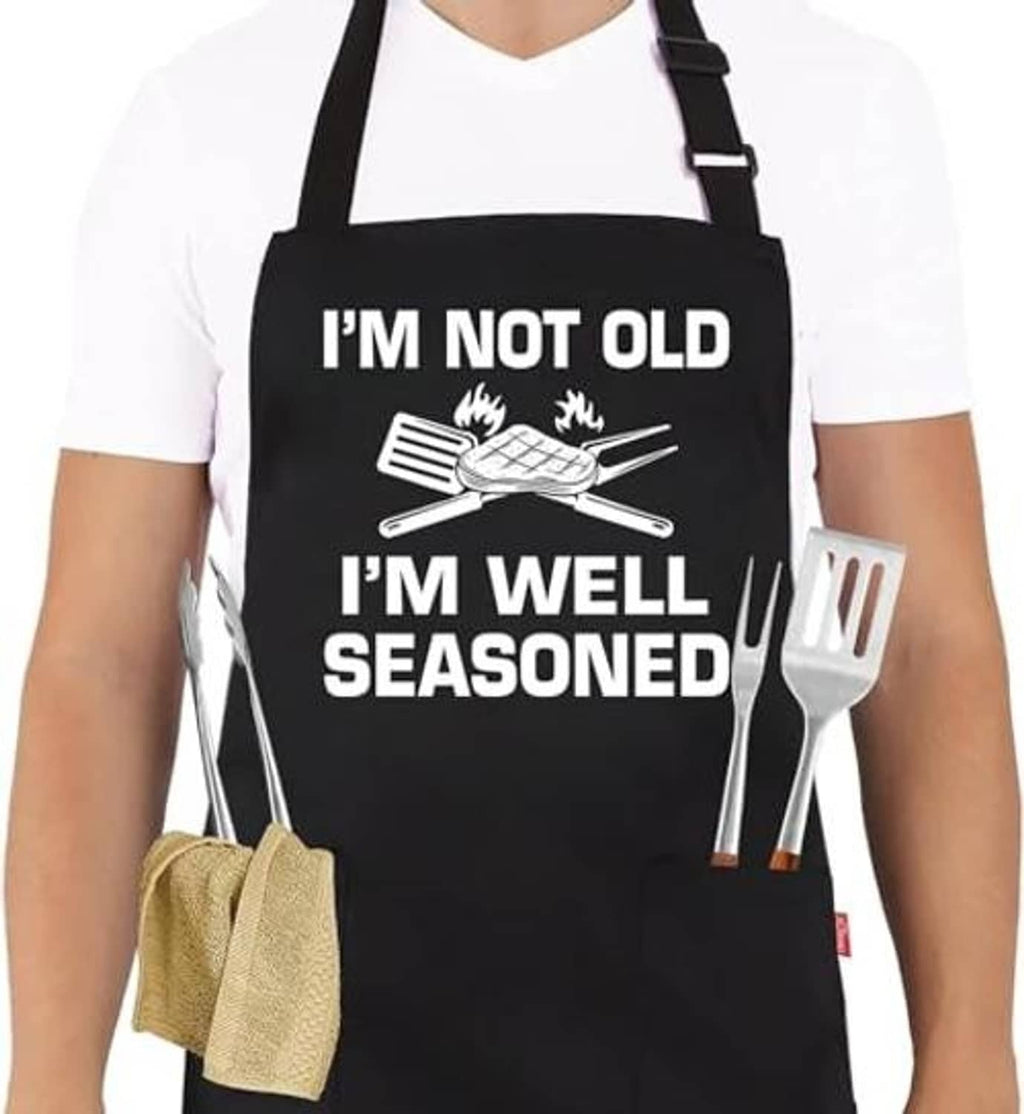 Black grilling apron with “I’M NOT OLD, I’M WELL SEASONED” graphic and front pockets