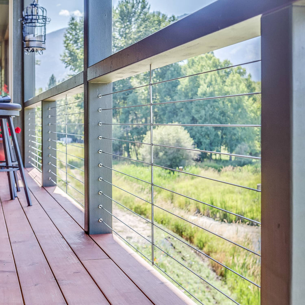 Stainless steel wheel protector sleeves on cable railing posts, outdoor deck installation