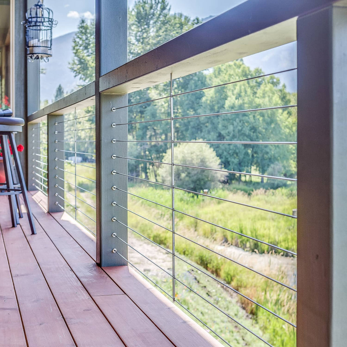 Stainless steel wheel protector sleeves on cable railing posts, outdoor deck installation