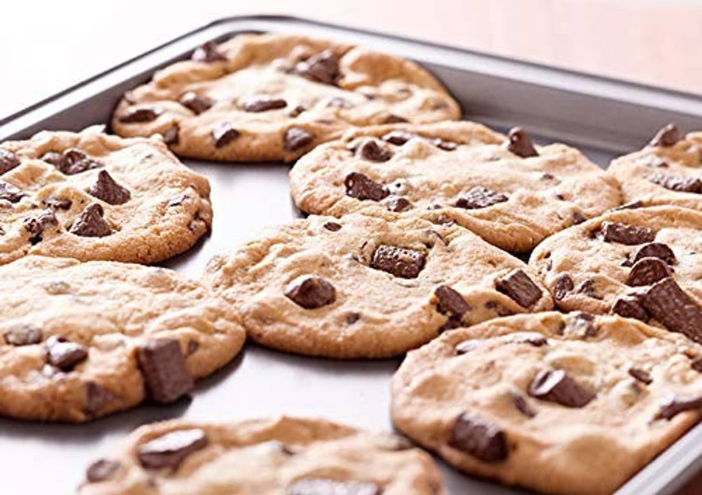 Silver sheet pan holding baked cookies with browned spots