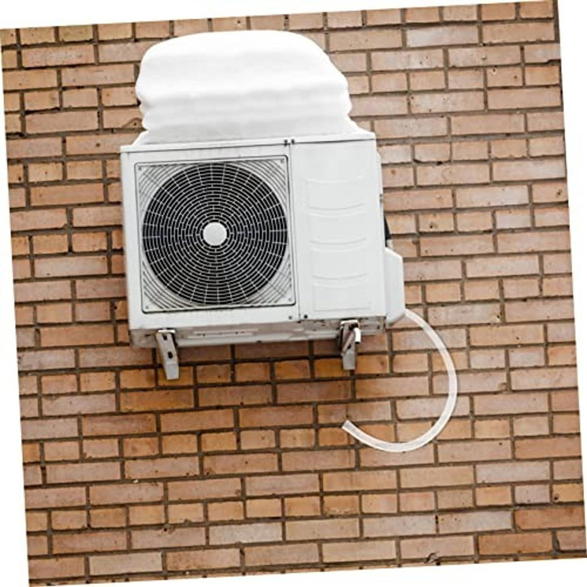 Air conditioner drain hose kit with white tube connected to outdoor AC unit