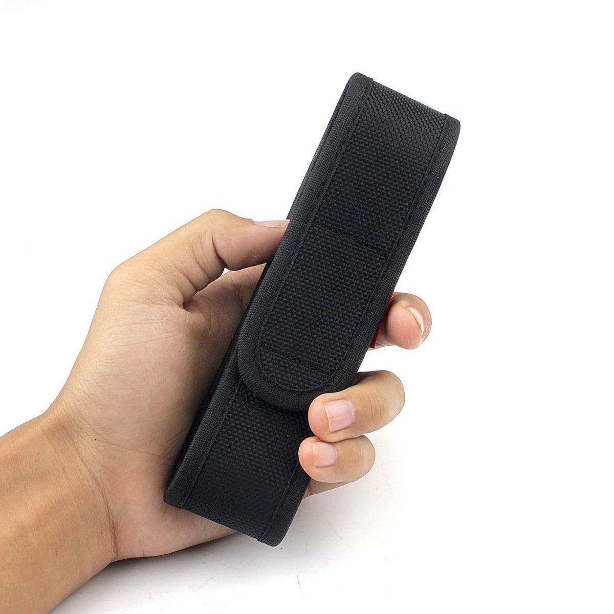 Black nylon flashlight holster held in hand, textured webbing and snap closure