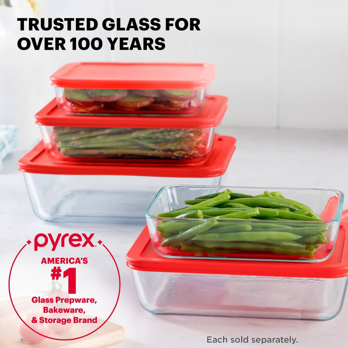 Stack of Pyrex glass containers with red lids, shown with green vegetables
