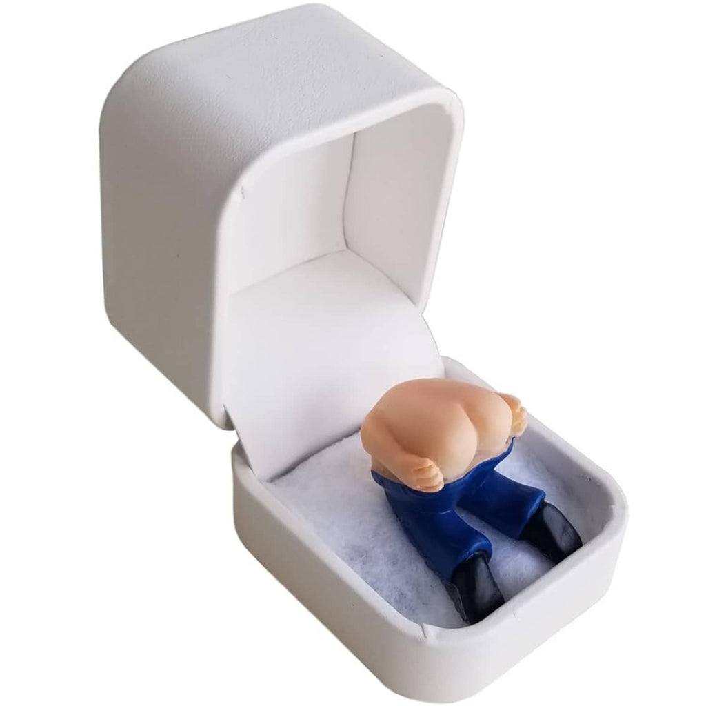White ring gift box with open lid and blue prank ring on gray insert
