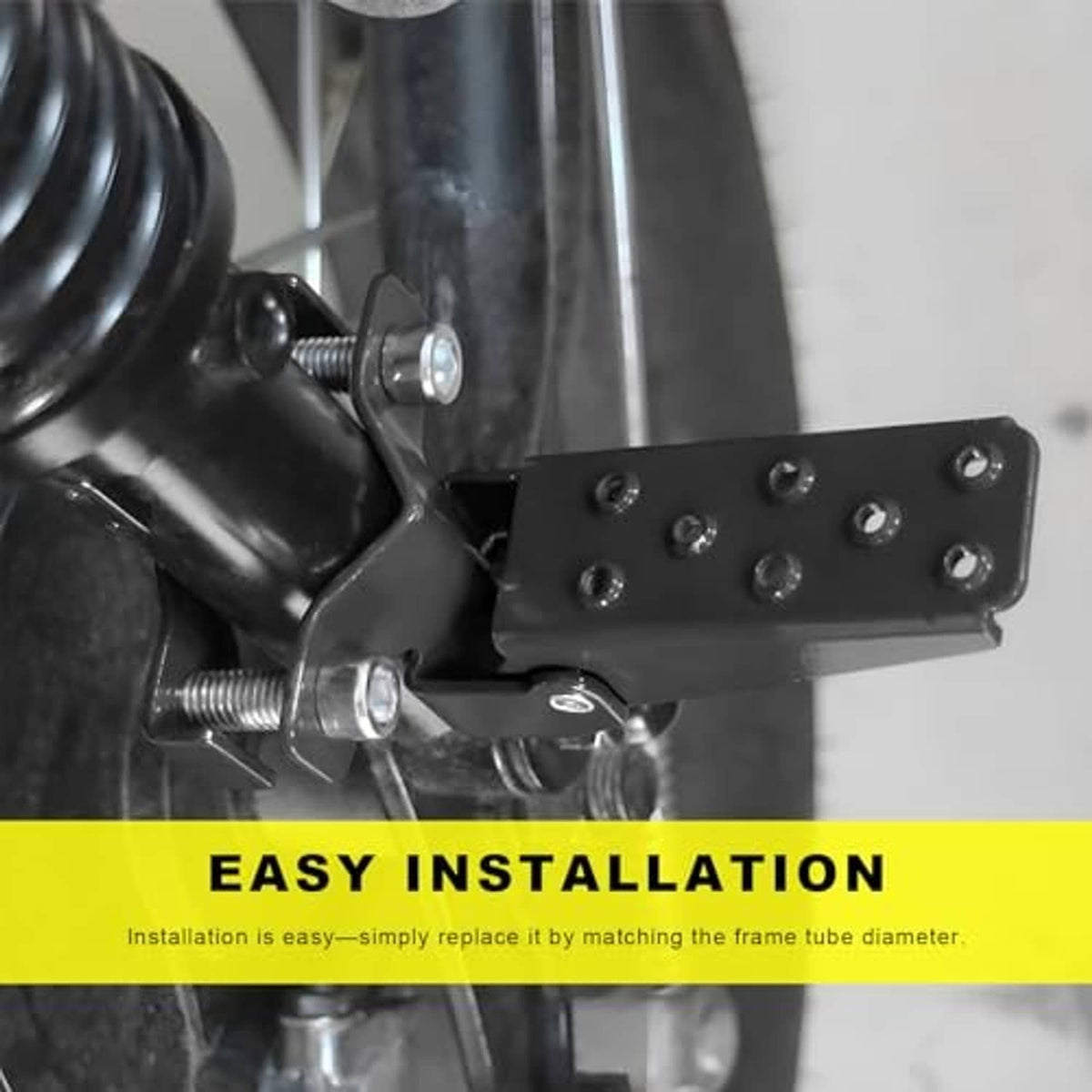 Black metal clamp-on footrest pedal with screw posts and mounting plate