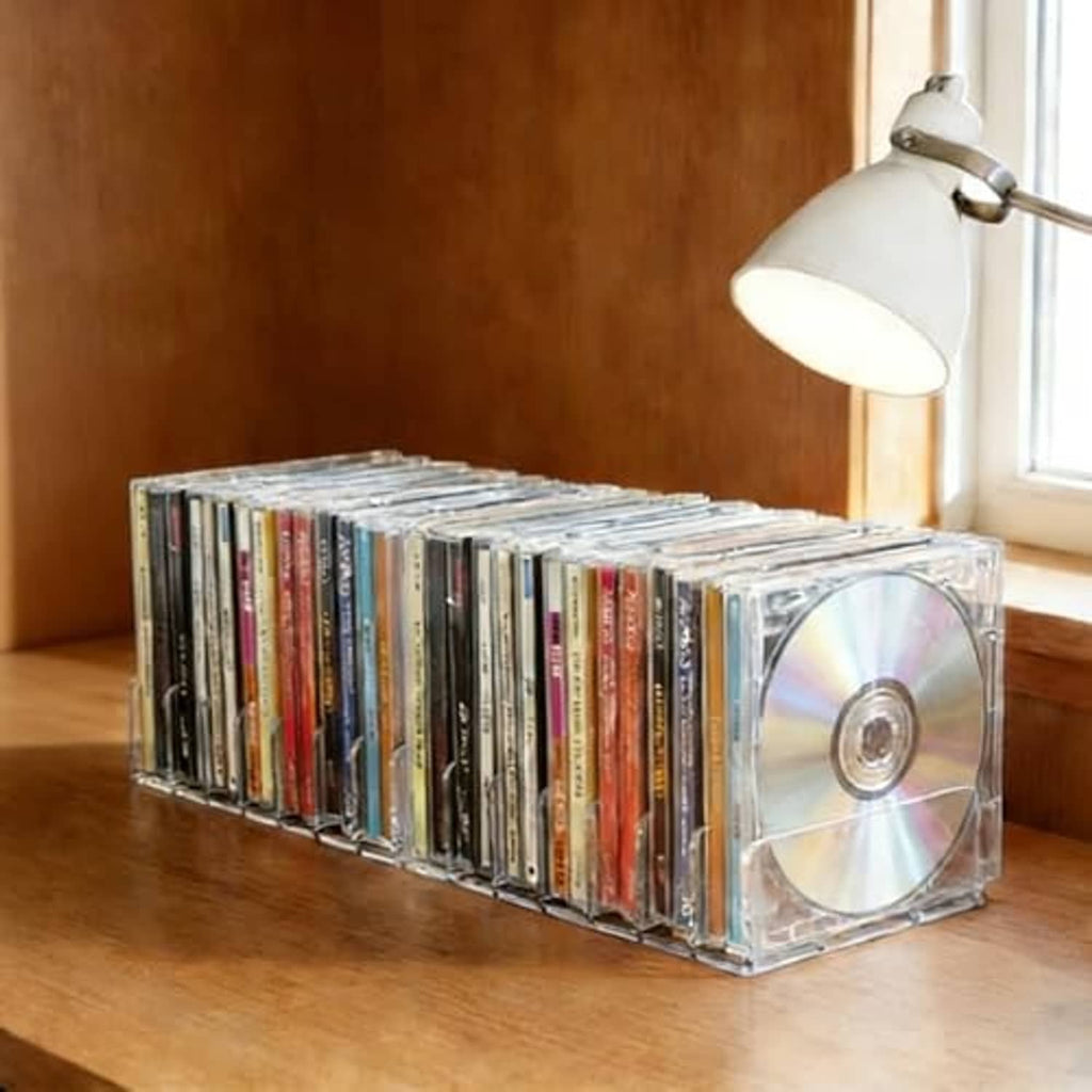 Clear acrylic CD organizer box with 7-slot trays holding multiple CDs with cases