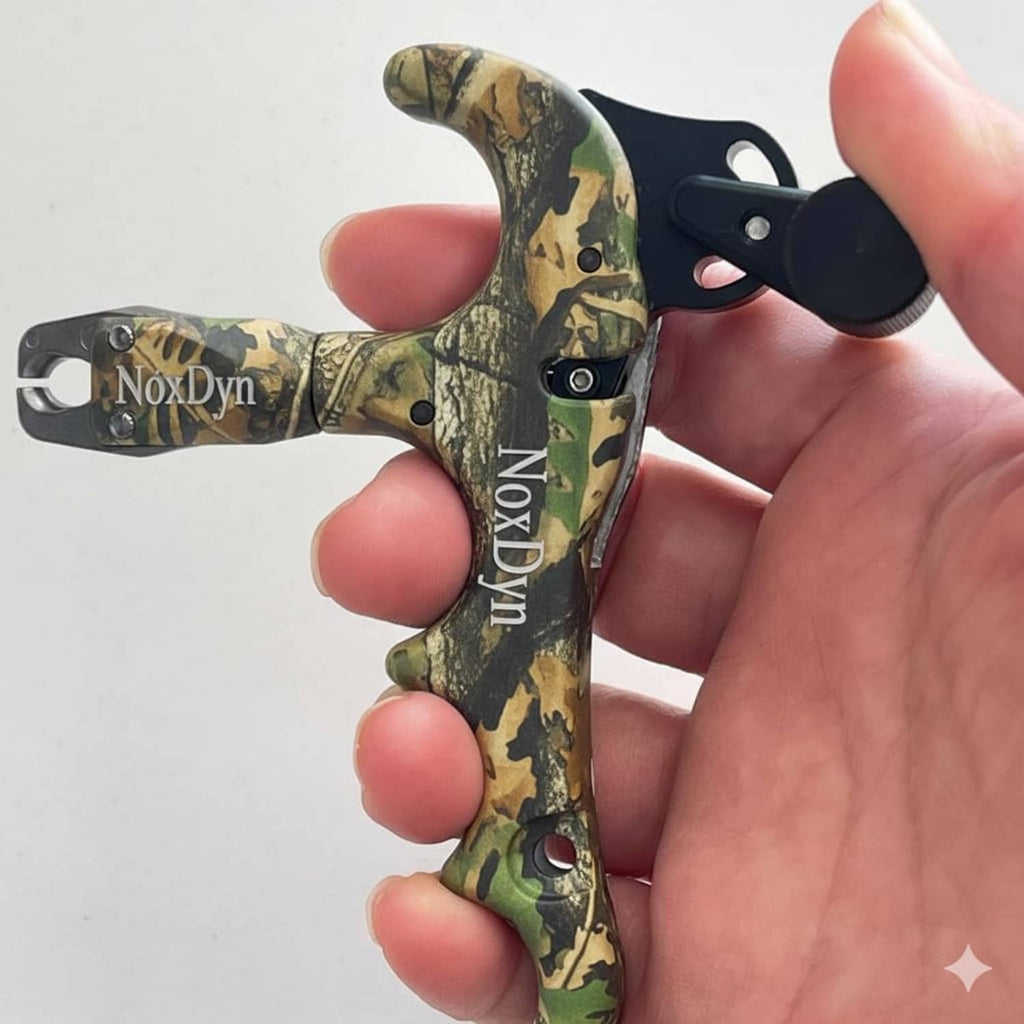 Archery bow thumb release in hand, black trigger with adjustable feel, green camo grip