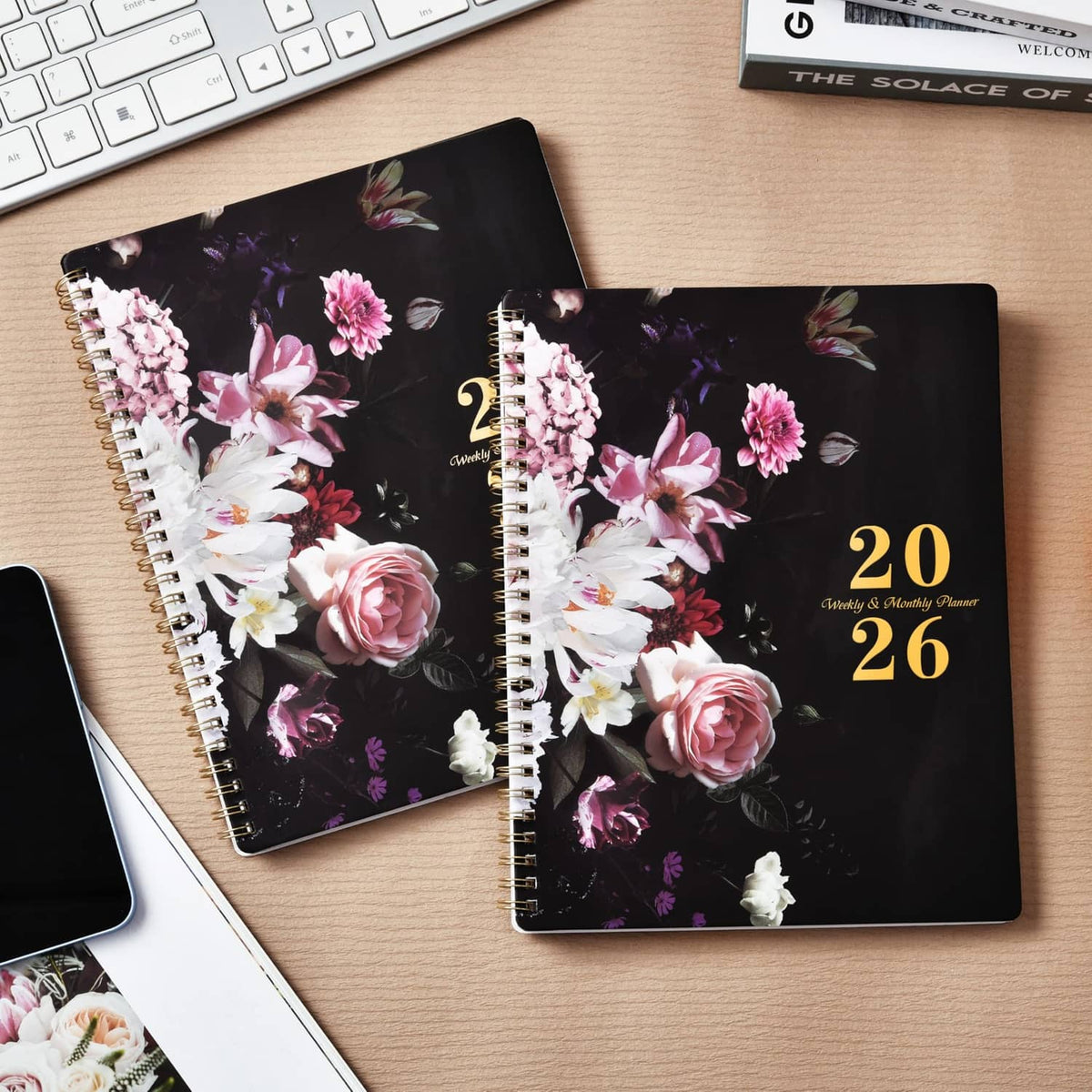 Two black 2026 planners with floral rose covers and gold "20 26" text, spiral binding